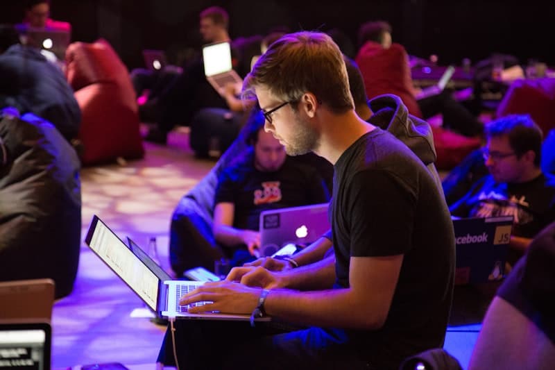 Person writing on a whiteboard during a team meeting
